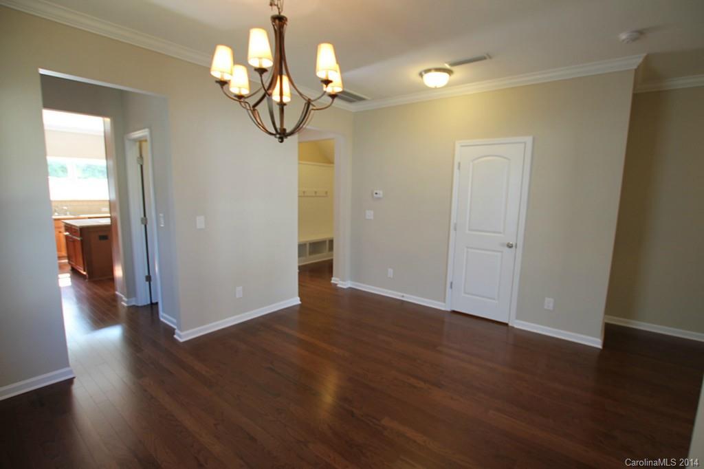 2176 Bluebell Way, Unit 172 Tega Cay, SC 29708 - Photo 3 of 22 a view of a hallway with wooden floor and chandelier