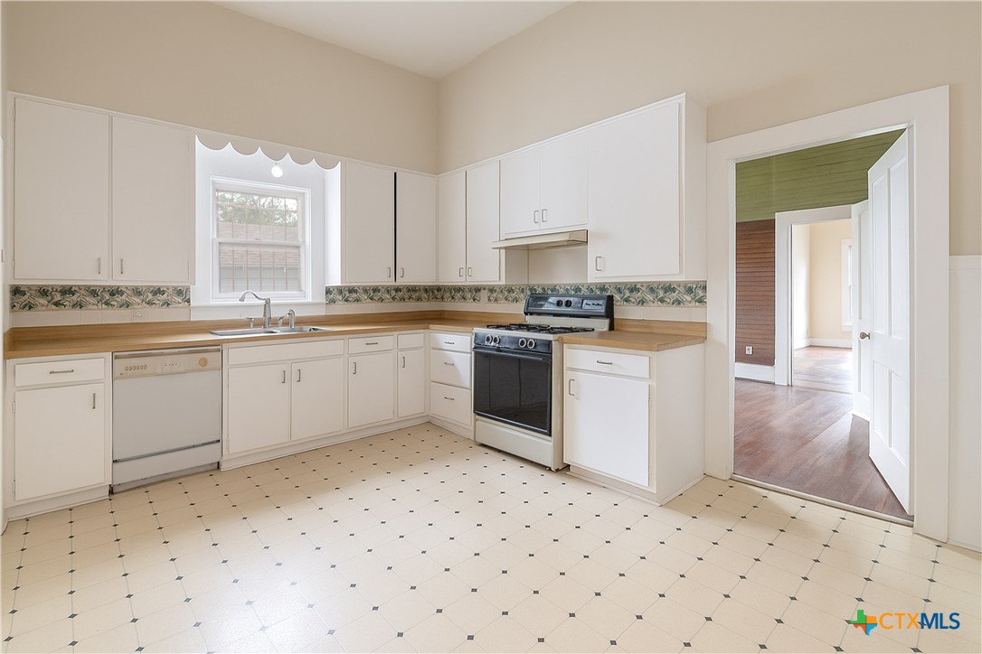 832 East Court Street Seguin, TX 78155 - Photo 14 of 31 a kitchen with a sink stove and cabinets