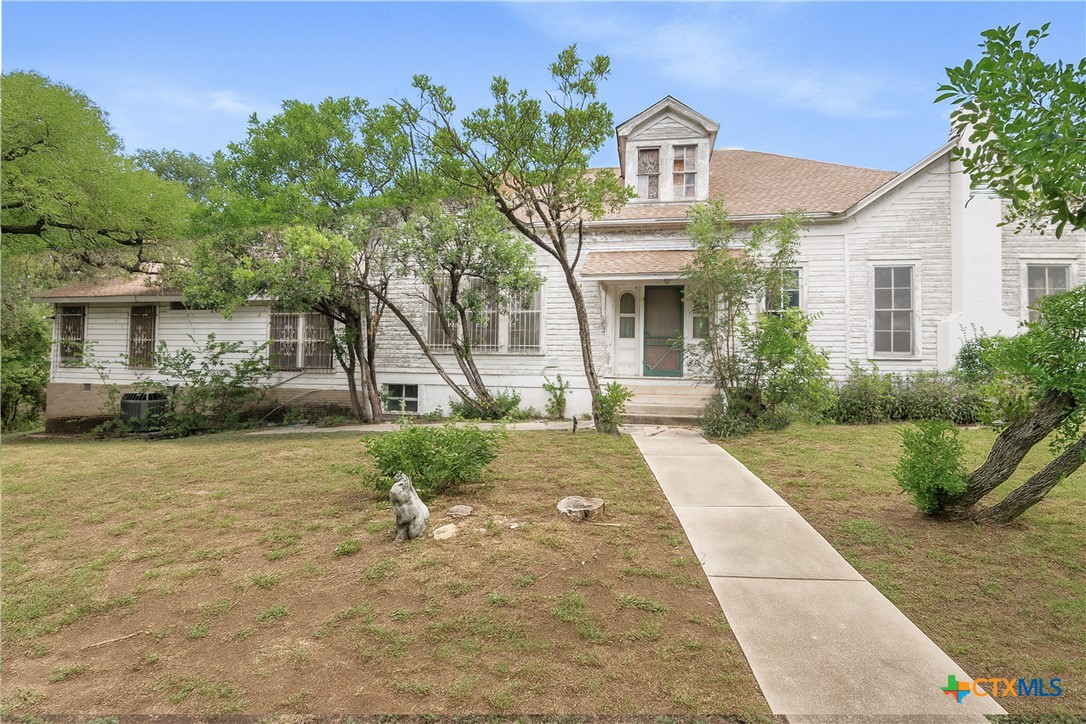 832 East Court Street Seguin, TX 78155 - Photo 2 of 31 a front view of a house with garden