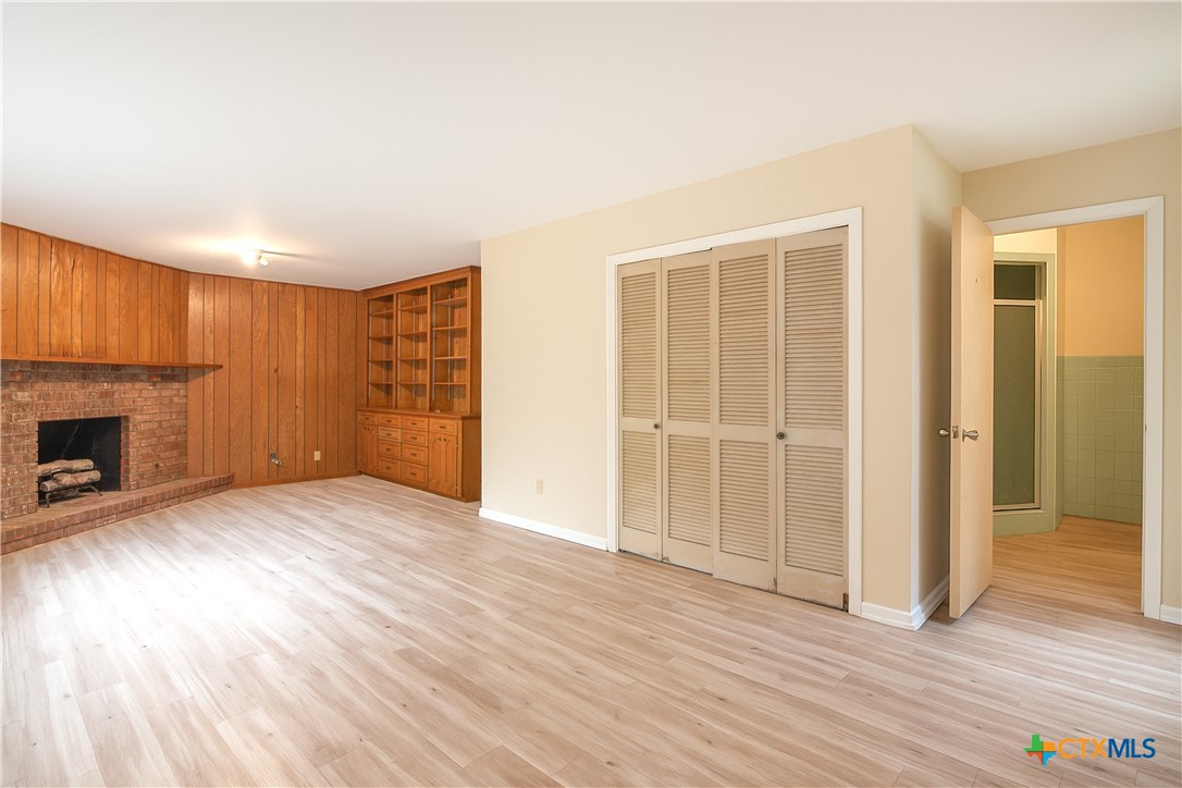 832 East Court Street Seguin, TX 78155 - Photo 22 of 31 an empty room with wooden floor fireplace and windows