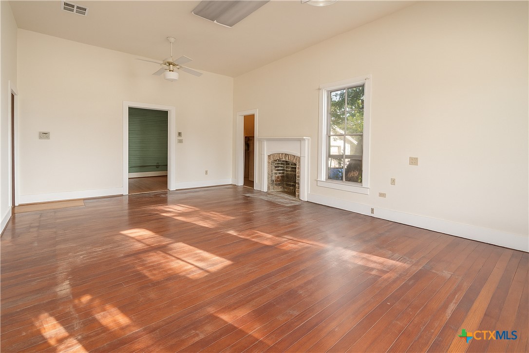 832 East Court Street Seguin, TX 78155 - Photo 4 of 31 an empty room with windows and fireplace