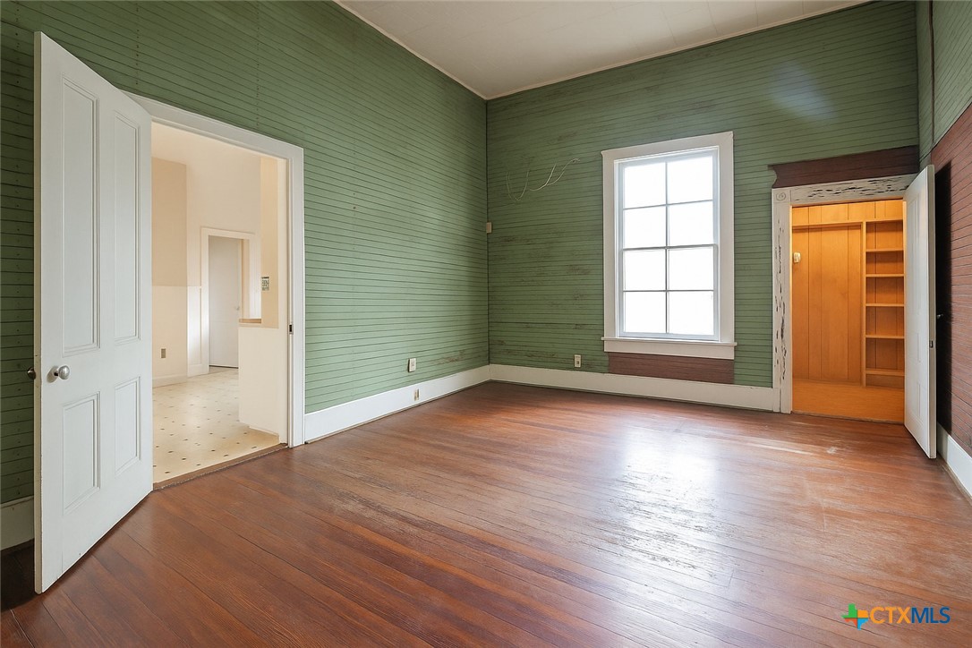 832 East Court Street Seguin, TX 78155 - Photo 5 of 31 an empty room with wooden floor and windows