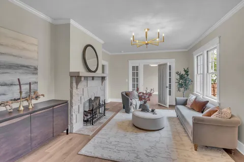 a living room with furniture a fireplace and a chandelier