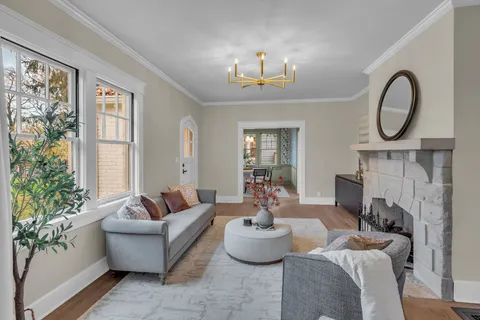 a living room with furniture a large window and a fireplace