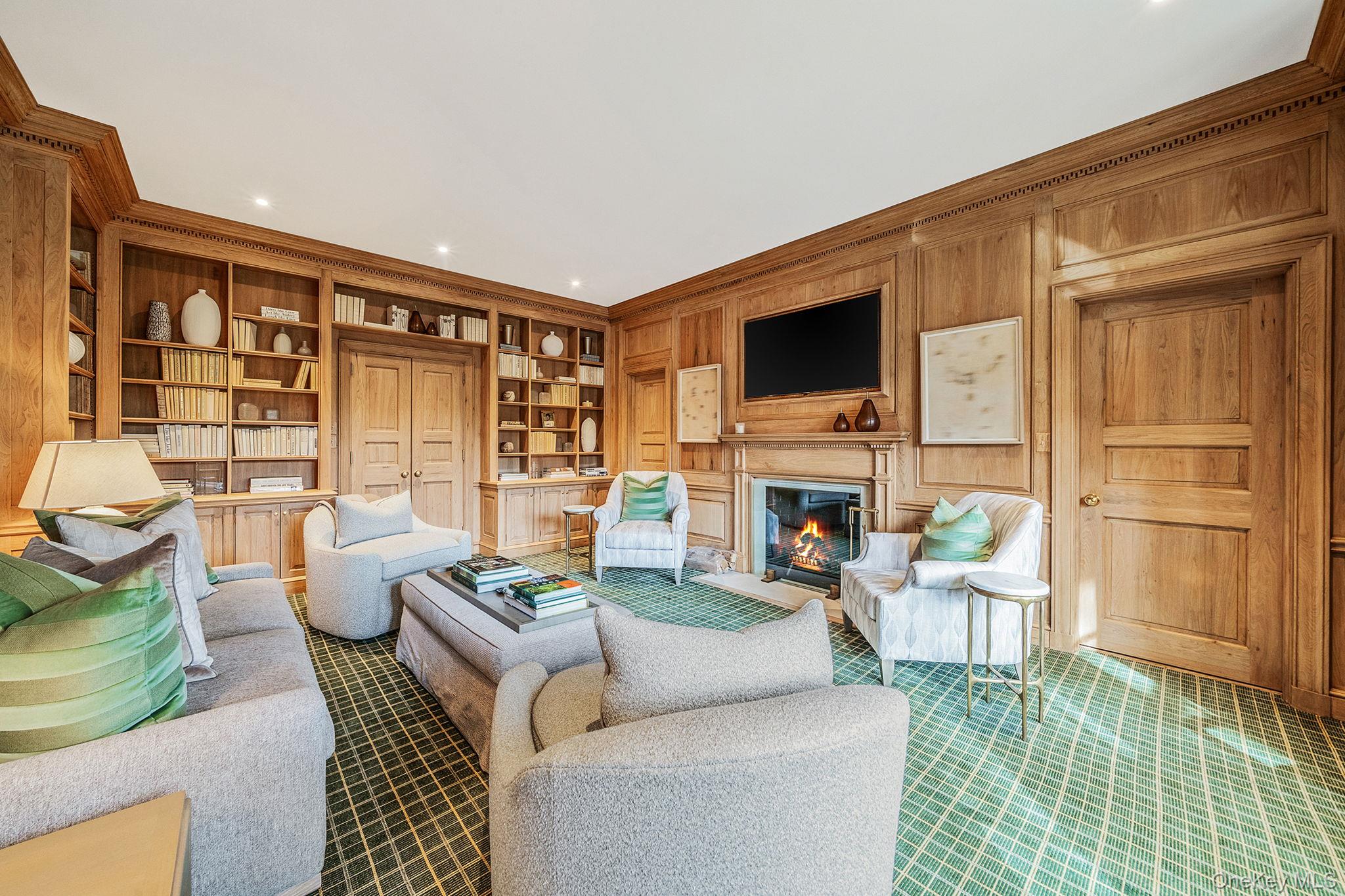 530 Chicken Valley Road Locust Valley, NY 11560 - Photo 11 of 50 Library with built in shelves, a glass covered fireplace