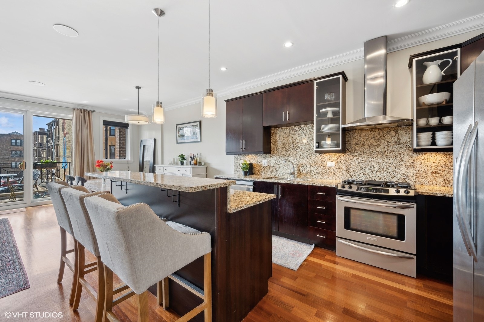 1430 West Irving Park Road, Unit 2 Chicago, IL 60613 - Photo 5 of 23 a kitchen with stainless steel appliances granite countertop a stove top oven a sink dishwasher a dining table and chairs with wooden floor