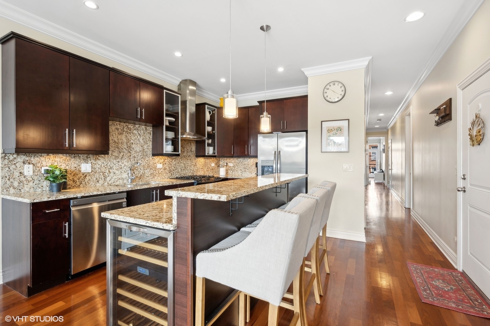 1430 West Irving Park Road, Unit 2 Chicago, IL 60613 - Photo 7 of 23 a large kitchen with stainless steel appliances kitchen island granite countertop a sink and cabinets