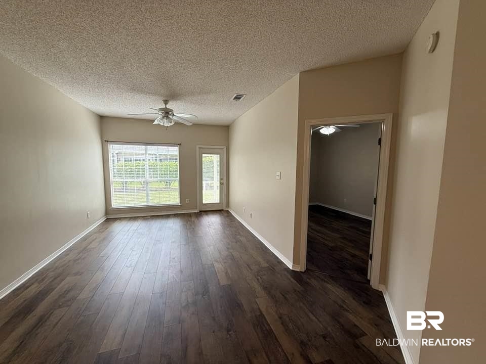 2651 South Juniper Street, Unit 401 Foley, AL 36535 - Photo 18 of 27 Empty room with dark wood finished floors, ceiling fan, baseboards, visible vents, and a textured ceiling