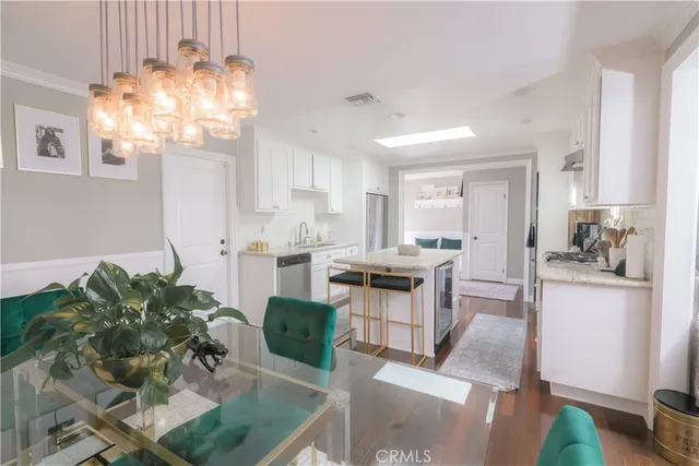 a kitchen with stainless steel appliances granite countertop a refrigerator a sink a stove and white cabinets