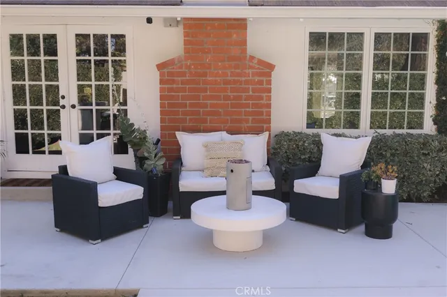 a view of a patio with couches table and chairs and potted plants