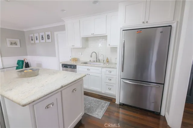a kitchen with a refrigerator sink and cabinets