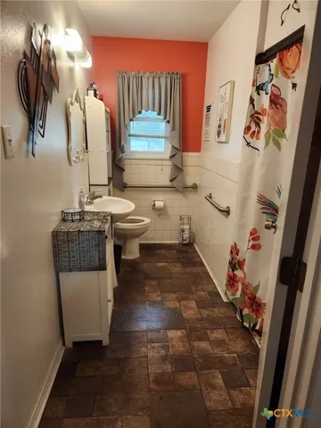 a bathroom with a sink a toilet and mirror