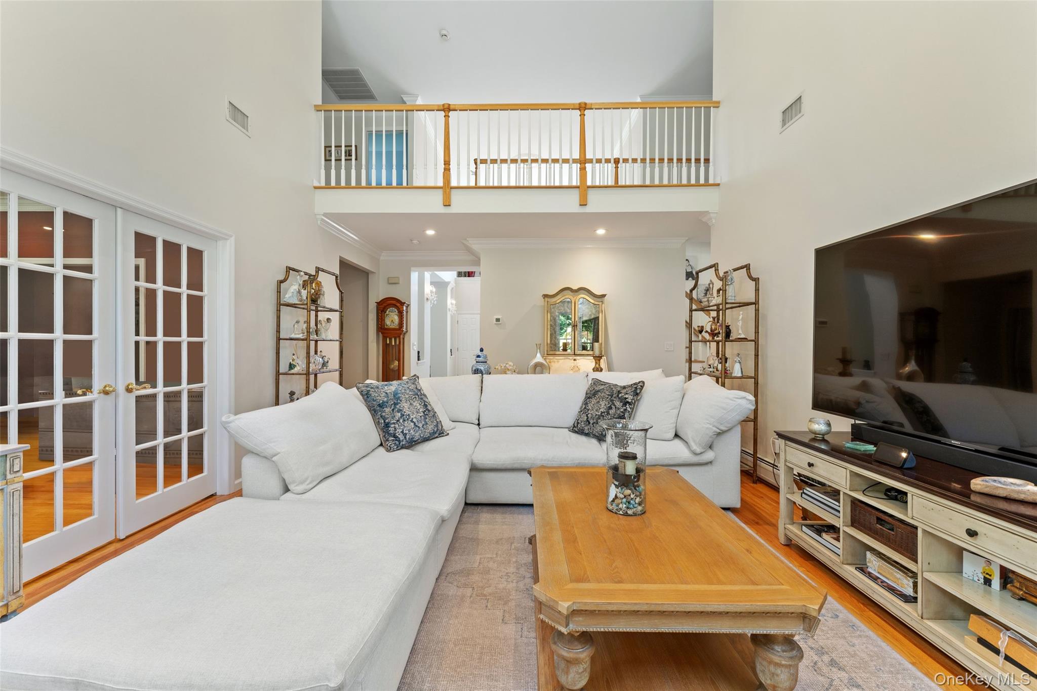 22 Perrin's Peak Road Stony Point, NY 10980 - Photo 27 of 47 Living room featuring light wood-style flooring, french doors, a towering ceiling, and crown molding