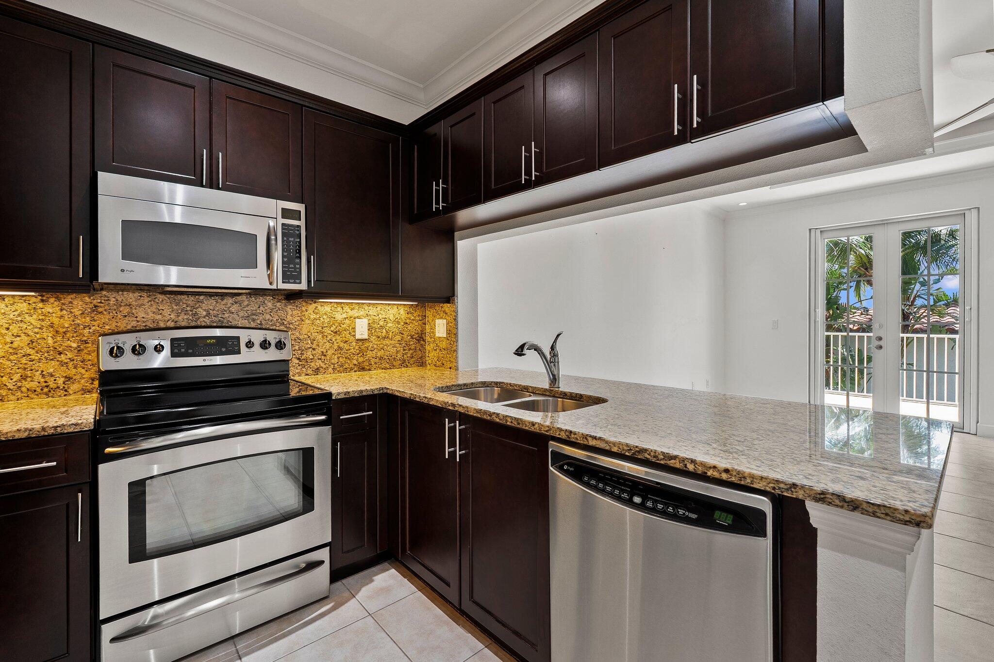 1579 Bow Line Road Fort Pierce, FL 34949 - Photo 19 of 56 a kitchen with stainless steel appliances granite countertop a sink stove and microwave