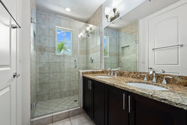 a bathroom with a granite countertop sink a toilet and shower