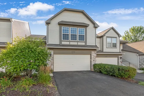 a front view of a house with a garden and garage