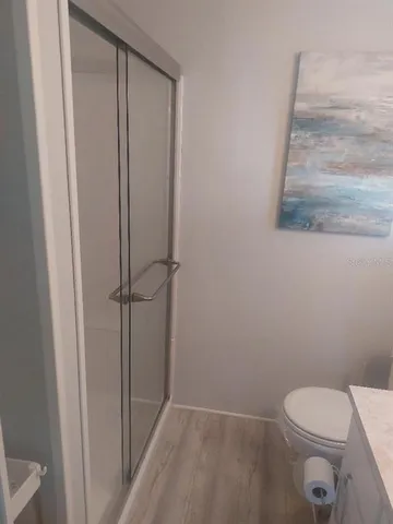 a white toilet sitting next to a shower