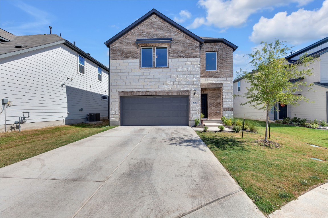 a front view of a house with a yard and garage