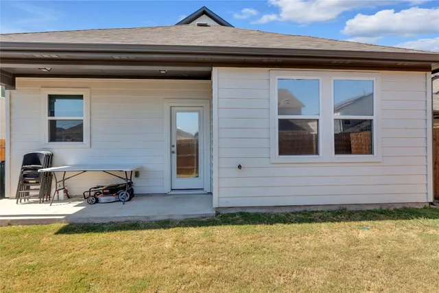 a view of a house with backyard and sitting area