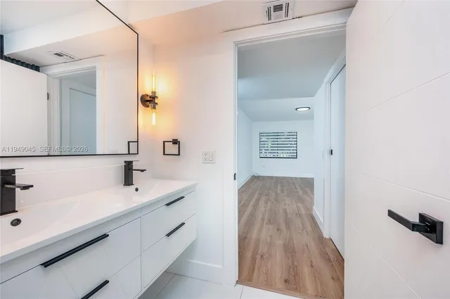 a spacious bathroom with a sink and a mirror