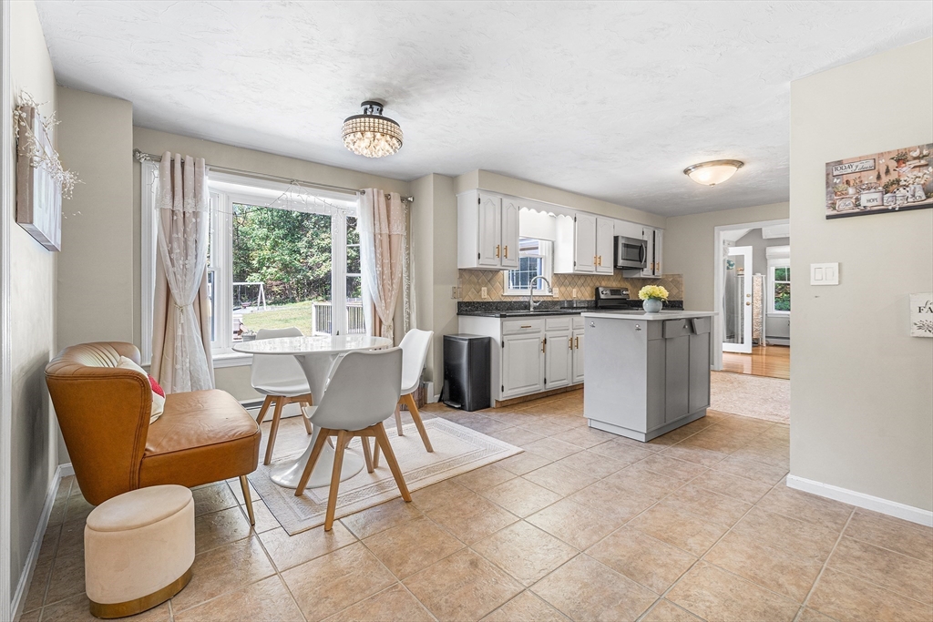 1 Jonathans Way Upton, MA 01568 - Photo 14 of 42 a kitchen with stainless steel appliances granite countertop a stove a sink a dining table and chairs