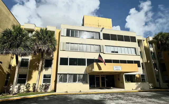 a front view of a building with a garden