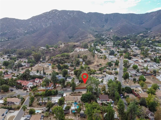 an aerial view of house with yard and mountain view in back