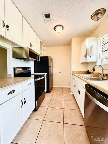 a kitchen with stainless steel appliances a refrigerator sink and microwave