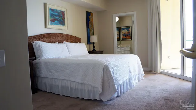 a bedroom with a bed and a flat tv screen next to a window
