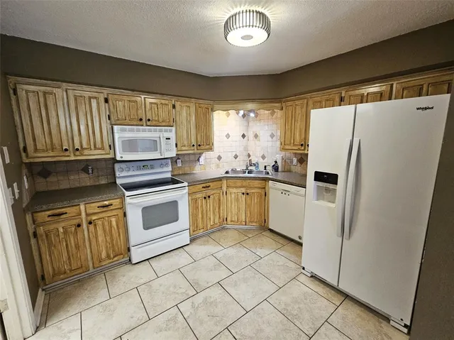 a view of a kitchen with fridge and window