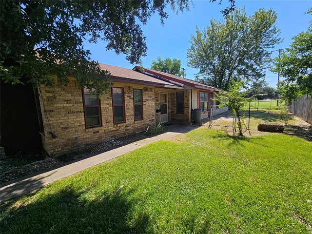 a view of a house with backyard and a tree