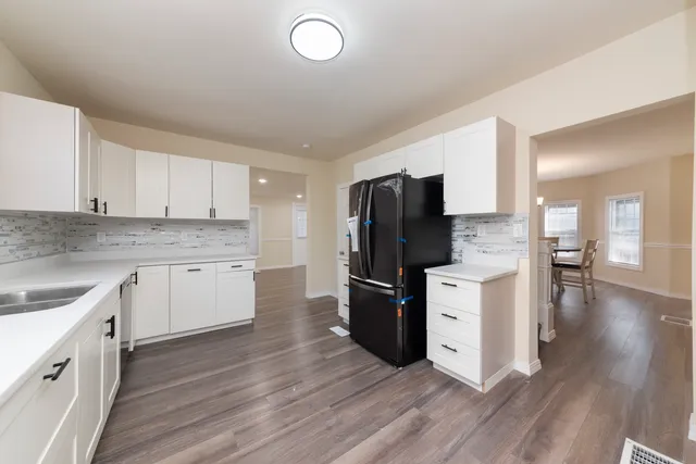 a kitchen with a refrigerator sink and cabinets