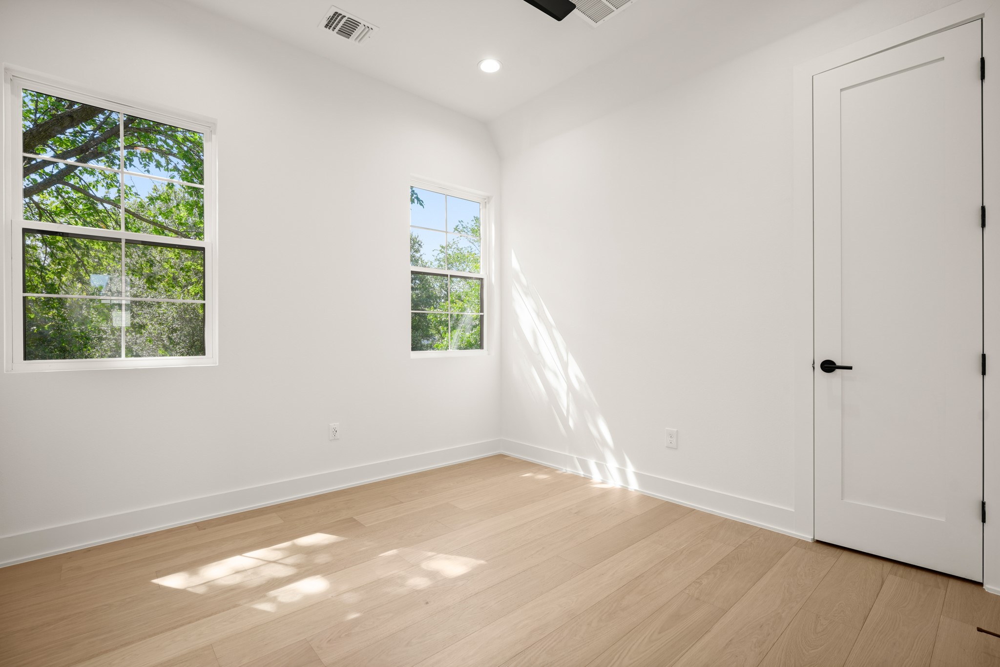 601 Vermont Road, Unit 2 Austin, TX 78702 - Photo 23 of 31 Hardwood floors and generous window lighting define this versatile, well-lit bedroom space.