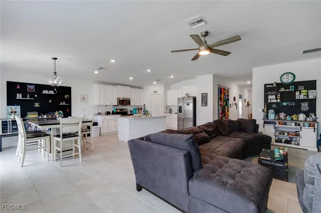 a living room with furniture and a view of kitchen