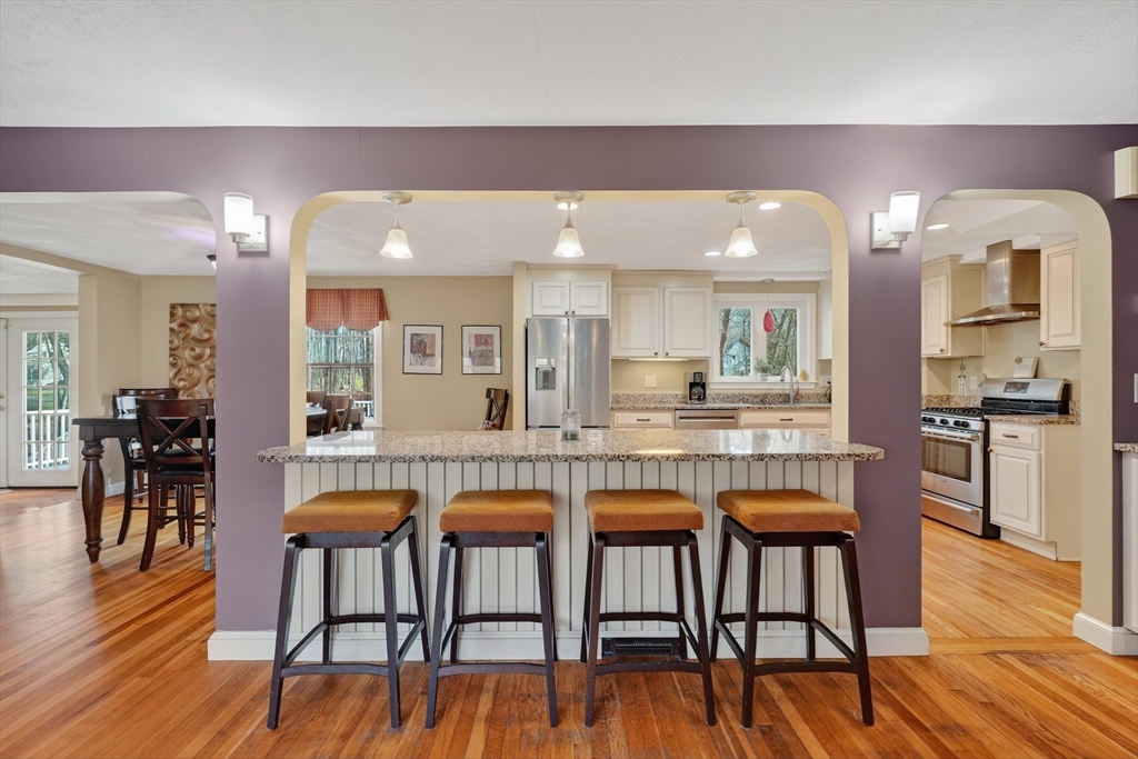 21 Fairbanks Road Chelmsford, MA 01824 - Photo 7 of 29 a kitchen with stainless steel appliances granite countertop table chairs and wooden floor