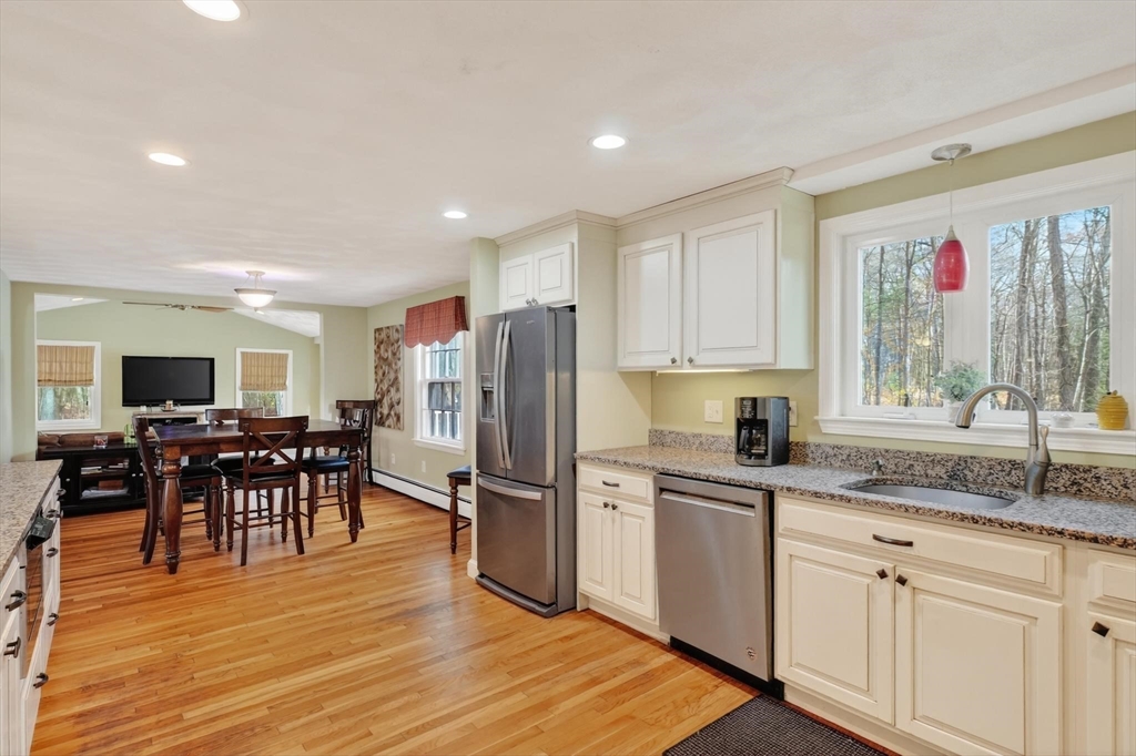 21 Fairbanks Road Chelmsford, MA 01824 - Photo 10 of 29 a kitchen with stainless steel appliances granite countertop a refrigerator a sink dishwasher a stove and white cabinets with wooden floor