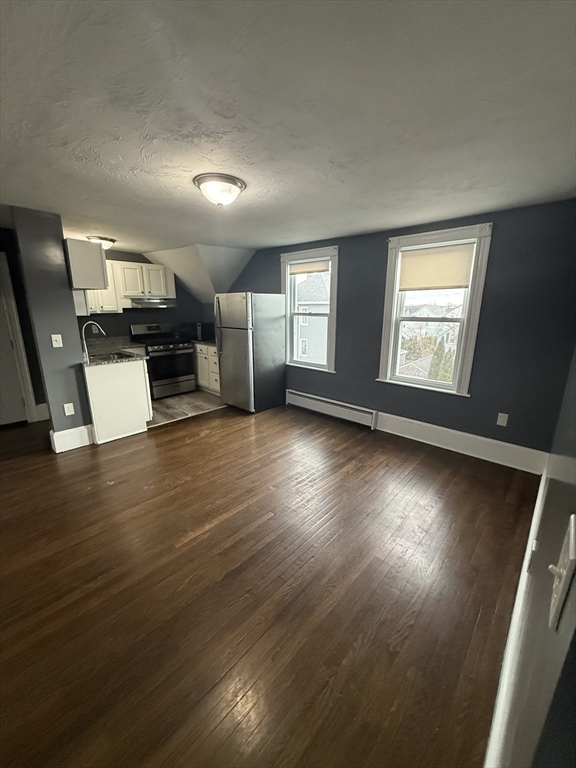 42 Mott Street, Unit 3 Fall River, MA 02721 - Photo 3 of 13 an empty room with wooden floor and windows