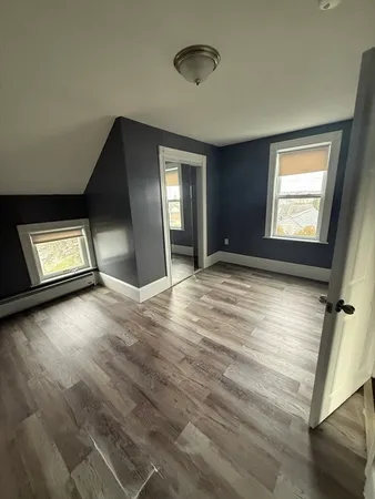 a view of an empty room and window and wooden floor