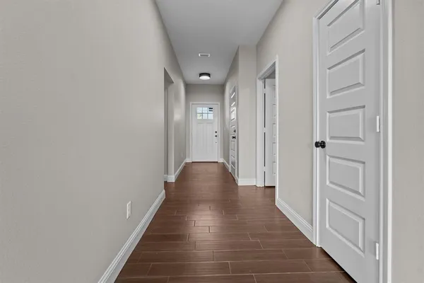 a view of a hallway with wooden floor and staircase