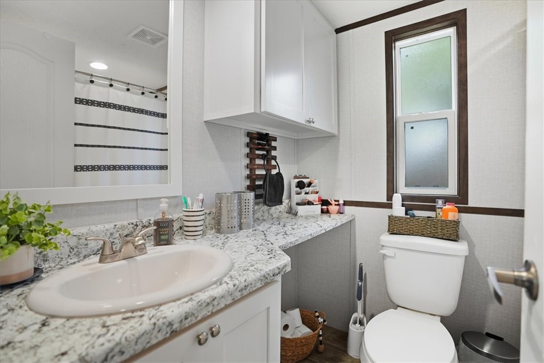 Undisclosed Address Rockport, TX 78382 - Photo 22 of 24 a bathroom with a granite countertop sink mirror and toilet
