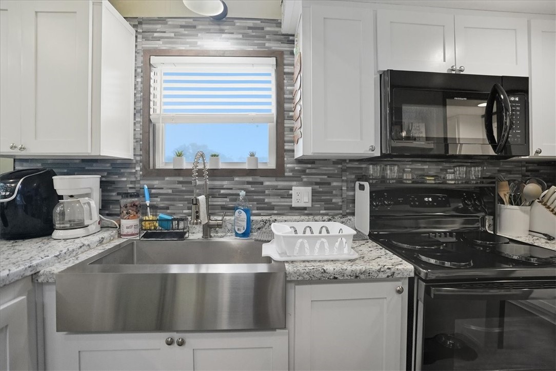 Undisclosed Address Rockport, TX 78382 - Photo 8 of 24 a kitchen with a stove and a white cabinets