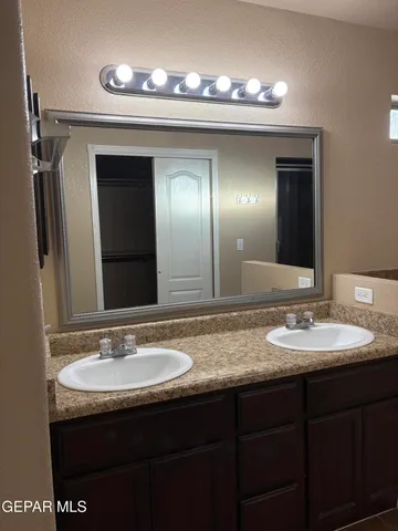 a bathroom with double vanity and a mirror