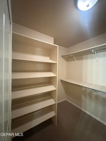 a view of walk in closet with empty racks