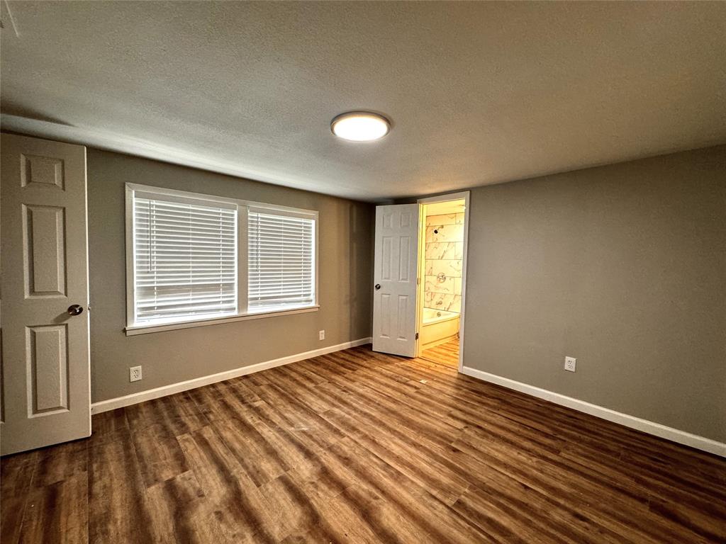 1931 Ave A Denison, TX 75021 - Photo 3 of 10 a view of an empty room with wooden floor and a window