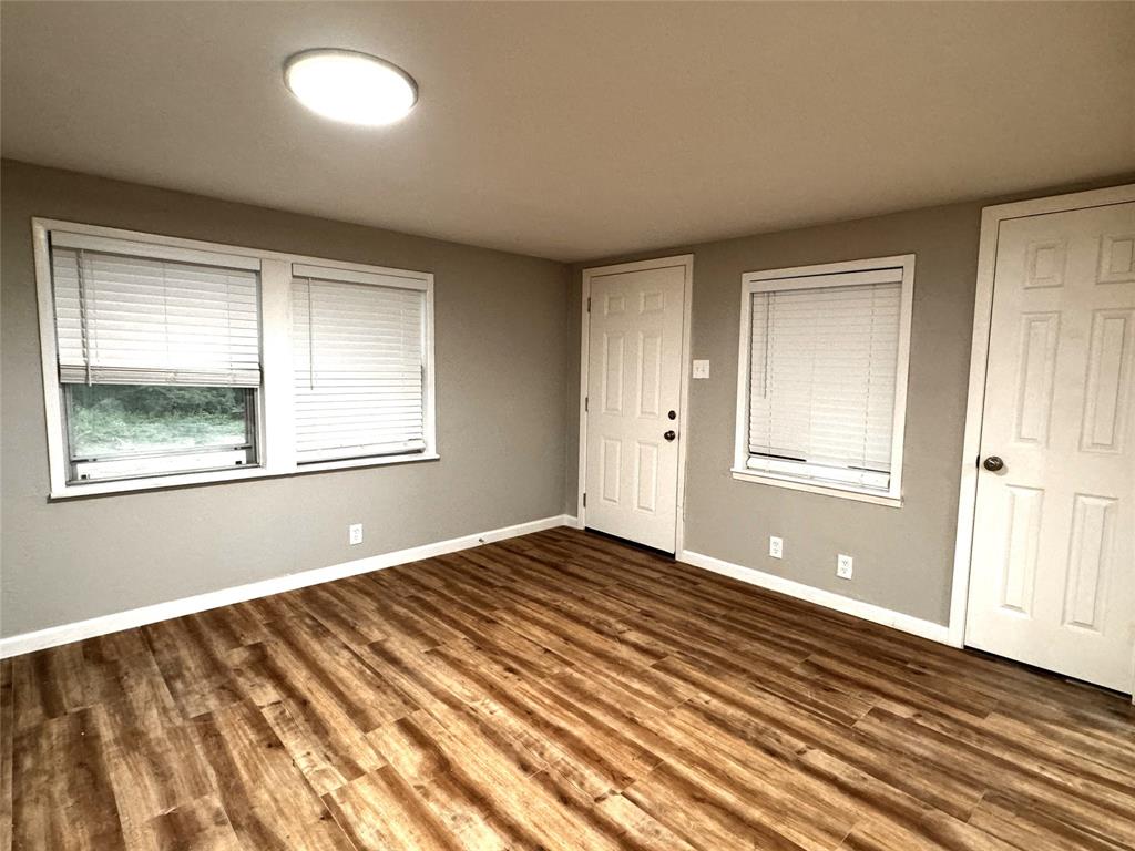1931 Ave A Denison, TX 75021 - Photo 5 of 10 a view of an empty room with wooden floor and a window