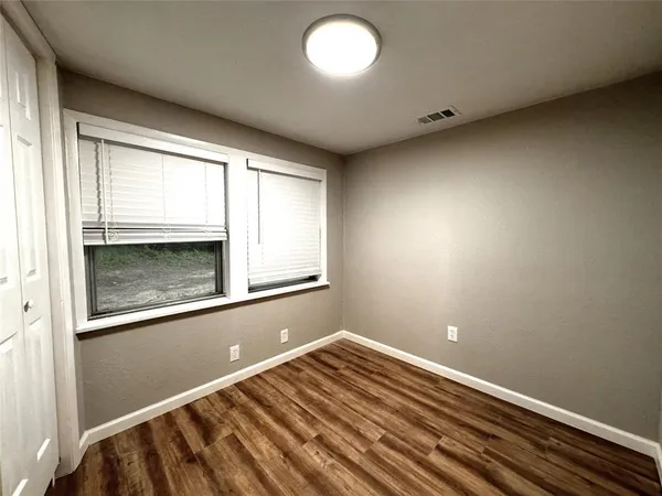a view of room with window and wooden floor
