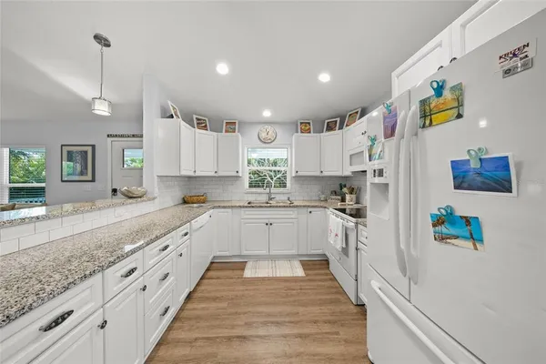 a kitchen with cabinets appliances a sink and a window