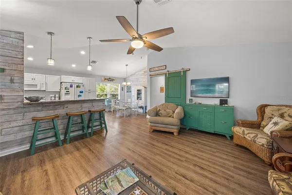 a living room with furniture ceiling fan and a wooden floor