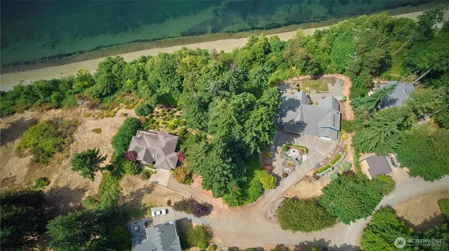 an aerial view of residential house with outdoor space and trees all around