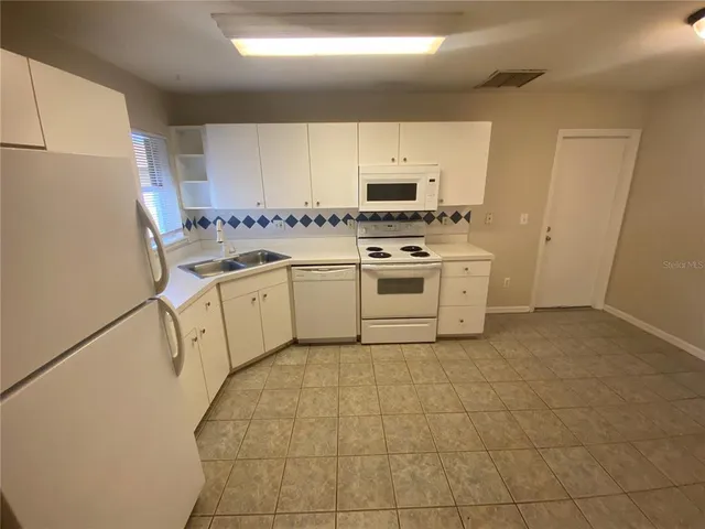 a kitchen with a stove a sink and a refrigerator
